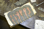 Hands mold - plasteline, originals, and plaster shell define area of the first part of the rubber mold.